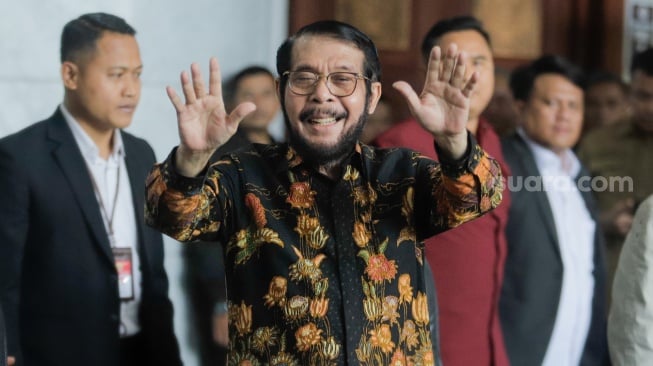 Mantan Ketua Mahkamah Konstitusi Anwar Usman menyapa awak media saat datang untuk memberikan keterangan pers di Gedung MK, Jakarta, Rabu (8/11/2023). [Suara.com/Alfian Winanto]